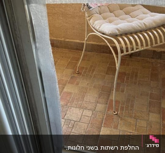 חלון עם תריסים פתוחים ומסגרת רשת קרועה